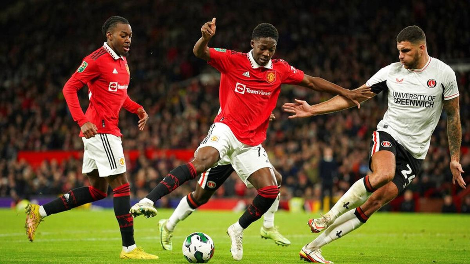 Kobbie Mainoo Manchester United sedang dribbling bola di Old Trafford